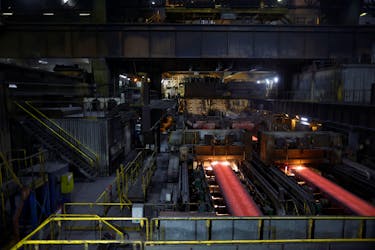 Red hot slabs of steel move along conveyors at the ArcelorMittal metals plant in Dunkirk as part of a media tour dedicated to the reduction of carbon intensity of the industry in France, January 16, 2023.