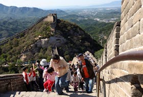A woman helps a child to climb the stairs amid tourists visiting the Badaling section of the Great Wall, in Beijing, China October 1, 2023.