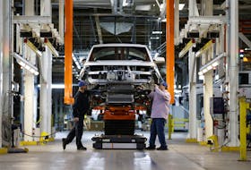 Workers tend to an unfinished Lordstown Motors Endurance electric pick-up truck on the assembly line at Foxconn's electric vehicle production facility in Lordstown, Ohio, U.S. November 30, 2022.