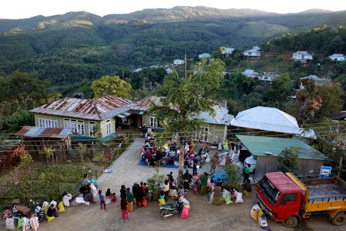 People who fled from Myanmar collect donated clothes at a temporary distribution centre at Farkawn village near the India-Myanmar border, in the northeastern state of Mizoram, India, November 20, 2021. Picture taken November 20, 2021.