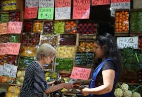 A woman buys fruits and vegetables at a greengrocery store in Buenos Aires, Argentina, December 12, 2023.
