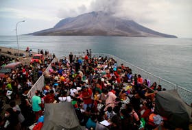 People board KRI Kakap-881 warship in the port of Tagulandang, to be evacuated to North Minahasa Regency on Sulawesi island, following the eruptions of Mount Ruang volcano in Sitaro, North Sulawesi province, Indonesia, May 1, 2024, in this photo taken by Antara Foto. Antara Foto/Andri Saputra/ via