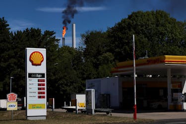 A Shell petrol station is seen as a pilot flame atop a flare stack burns at the refinery of the Shell Energy and Chemicals Park Rheinland in Godorf near Cologne, Germany, August 3, 2022. 