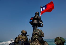 Members of Taiwan's Navy and media onboard a special operation boat with a Taiwanese flag fluttering over it during a drill part of a demonstration for the media, to show combat readiness ahead of the Lunar New Year holidays, on the waters near a military base in Kaohsiung, Taiwan January 31, 2024.