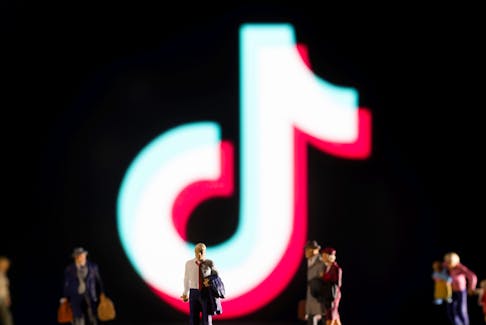 File photo: Small figurines are seen in front of displayed Tik Tok logo in this illustration taken February 11, 2022.
