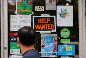A pedestrian passes a "Help Wanted" sign in the door of a hardware store in Cambridge, Massachusetts, U.S., July 8, 2022.