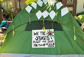 A sign adorns a tent at a protest encampment in support of Palestinians in Gaza, as student activists join campuses across the United States in a call on their universities to divest financial ties from Israel, in University Yard at George Washington University in Washington, U.S., May 1, 2024.