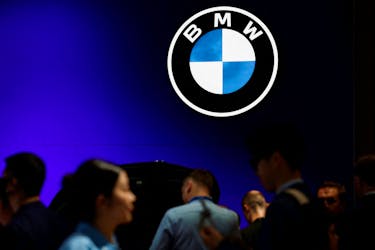 FILE PHOTO:Visitors walk past a BMW logo at the Beijing International Automotive Exhibition, or Auto China 2024, in Beijing, China, April 25, 2024.