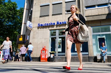 A woman walks in front of a branch of Germany's Deutsche Bank in Cologne, Germany, July 18, 2016. 
