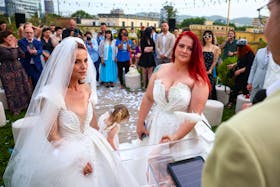 Alba Ahmetaj and Edlira Mara look on during their wedding ceremony at the rooftop of the Mayor's office, even though no law allows same-sex marriage, in Tirana, Albania, May 19, 2024.