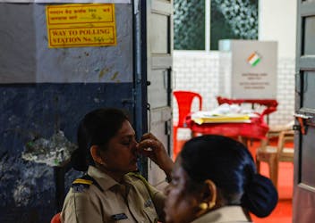 A policewoman practices alternate nostril breathing outside a polling booth before voting begins, during the fifth phase of India's general election, in Mumbra, on the outskirts of Mumbai, India, May 20, 2024.