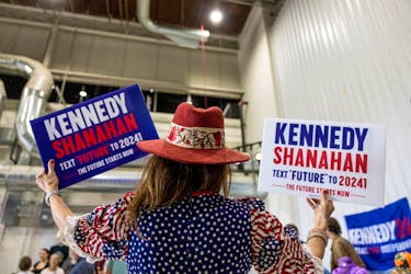 Bonnie Eckert raises signs supporting independent U.S. presidential candidate Robert F. Kennedy Jr. during a campaign event in Aurora, Colorado, U.S., May 19, 2024. 