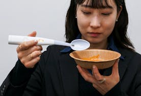 An employee of Kirin Holdings demonstrates an electric spoon, jointly developed with Meiji University's School of Science and Technology professor Homei Miyashita, that can enhance the salty taste in food, in Tokyo, May 20, 2024.