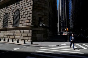 A man walks by the Federal Reserve Bank of New York Building in New York City, U.S., April 26, 2021.