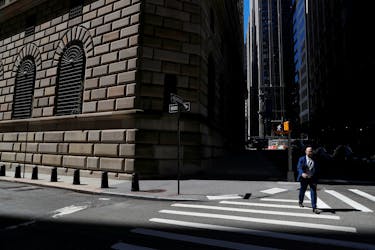 A man walks by the Federal Reserve Bank of New York Building in New York City, U.S., April 26, 2021.