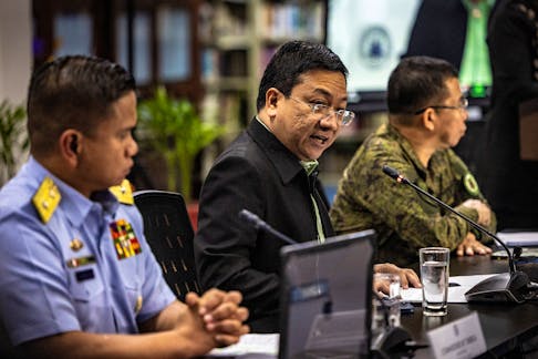 Philippine Coast Guard spokesperson for the West Philippine Sea Commodore Jay Tarriela (left), National Security Council spokesperson Jonathan Malaya (center), and Armed Forces of the Philippines spokesperson Colonel Medel Aguilar speak to the press during a news conference in response to recent aggression of the Chinese Coast Guard against Philippine vessels in the South China Sea, at the Department of Foreign Affairs in Manila, Philippines, August 07, 2023. Ezra Acayan/Pool via