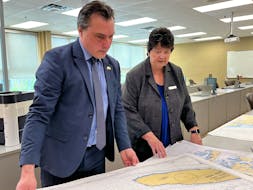 Shelburne County MLA Nolan Young and Mary Thompson, principal, NSCC Burridge, Shelburne Campus and Digby Site look through the stack of nautical charts to be used with the new marine simulator at the school of fisheries at the NSCC Shelburne Campus. Kathy Johnson