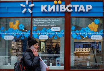 FILE PHOTO:A woman walks past a store of Ukraine's telecommunications company Kyivstar, amid Russia's attack on Ukraine, in Kyiv, Ukraine December 12, 2023.