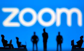 Small toy figures are seen in front of Zoom logo in this illustration picture taken March 15, 2021.