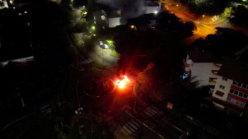 A car is seen lit on fire, amid protests against plans to allow more people to take part in local elections in the French-ruled territory, which indigenous Kanak protesters reject, in Noumea, New Caledonia May 18, 2024 in this screengrab from video obtained by Reuters. Video Obtained by Reuters/via REUTERS /File Photo