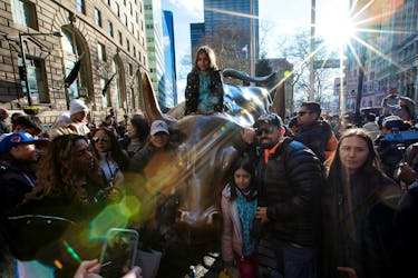 People visit the Charging Bull at the Financial District by the New York Stock Exchange (NYSE) in New York, U.S., December 29, 2023.