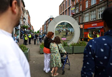 People in Dublin greet New Yorkers as they interact with The Portal, a public technology sculpture that links with direct connection between Dublin, Ireland and the Flatiron district in Manhattan, New York City, in Dublin, Ireland, May 21, 2024.