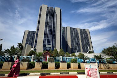 A woman walks past the Central Bank building after the monthly Monetary Policy Committee meeting in Abuja, Nigeria May 22, 2018.