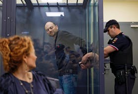 A police officer removes handcuffs from Jailed Russian opposition figure Vladimir Kara-Murza during a court hearing to consider an appeal against his prison sentence, in Moscow, Russia July 31, 2023.