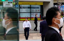 Pedestrians walk past an electric monitor displaying the Japanese yen exchange rate against the U.S. dollar outside a brokerage in Tokyo, Japan March 28, 2024.