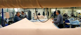 Men work on cutting material at the Fashion Enter factory in London England, January 8, 2016.