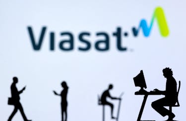 Small toy figures with laptops and smartphones are seen in front of displayed Viasat Internet logo, in this illustration taken December 5, 2021.