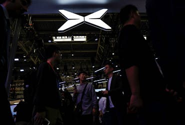 FILE PHOTO:Visitors walk past a Xpeng logo at the Beijing International Automotive Exhibition, or Auto China 2024, in Beijing, China, April 25, 2024.