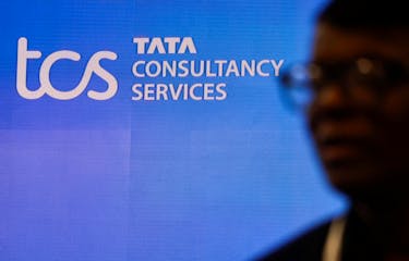 A man walks past a logo of Tata Consultancy Services (TCS) before a press conference announcing the company's quarterly results in Mumbai, India, January 11, 2024.