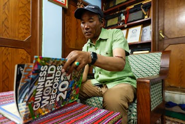 Kami Rita Sherpa, 53, a Nepali Mountaineer who climbed Mount Everest for a record 28 times, goes through the Guinness World Records 2021 book to show his pictures on them after an interview with Reuters at his rented apartment in Kathmandu, Nepal May 28, 2023.