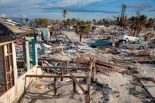 Debris left by Hurricane Idalia is stacked along a street in Cedar Key, Fla., Aug. 31, 2023. - Zack Wittman/The New York Times