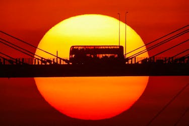 A double-decker bus passes through Ting Kau Bridge at sunset in Hong Kong, China October 25, 2023.