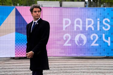 French Prime Minister Gabriel Attal stands next to a Paris 2024 Olympic Games sign as he attends ceremonies marking the end of World War II anniversary (Victory Day), in Paris, France, May 8, 2024. Michel Euler/Pool via