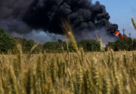 A fire from a gas processing plant continues to burn behind a field of wheat after the plant was hit by shelling a few days prior in Andriivka in the Kharkiv region as Russia's attack on Ukraine continues in Ukraine, June 21, 2022.