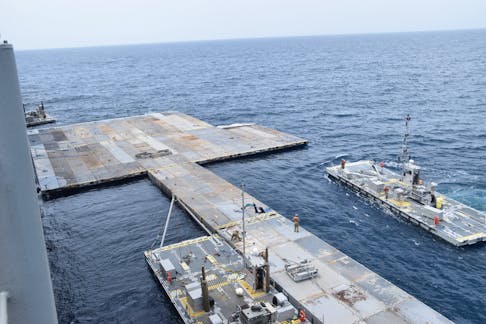 U.S. Army Soldiers assigned to the 7th Transportation Brigade (Expeditionary) and U.S. Navy sailors attached to the MV Roy P. Benavidez assemble the Roll-On, Roll-Off Distribution Facility (RRDF), or floating pier, to assist in the delivery of humanitarian aid to the people of Gaza, in the Mediterranean Sea April 26, 2024.   U.S. Army Central/Handout via