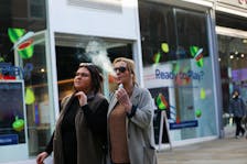 A woman holds an e-cigarette as she vapes on a street in Manchester, Britain March 6, 2024.
