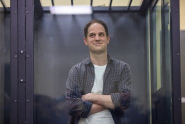 Wall Street Journal reporter Evan Gershkovich, who is in custody on espionage charges, stands behind a glass wall of an enclosure for defendants as he attends a court hearing in Moscow, Russia, April 23, 2024.