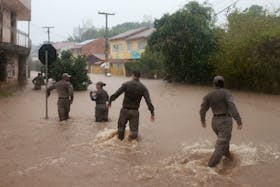 Brazilian military police search for people in a flooded area in Cavalhada neighbourhood after heavy rains in Porto Alegre, Brazil May 23, 2024.