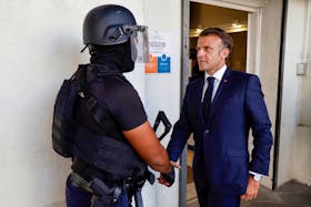 French President Emmanuel Macron shakes hands with a policeman upon his arrival at the central police station in Noumea, France's Pacific territory of New Caledonia on May 23, 2024. LUDOVIC MARIN/Pool via