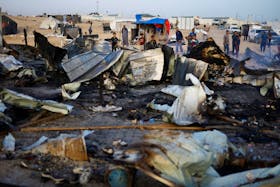 Palestinians look at the damages after a fire at the site of an Israeli strike on an area designated for displaced people, in Rafah in the southern Gaza Strip, May 27, 2024.