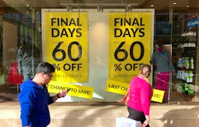 Shoppers walk past sales signs on display in the window of a retail store at a shopping mall in Sydney, Australia, September 4, 2018. Picture taken September 4, 2018.
