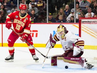 Boston College goaltender Jacob Fowler blocks a shot as Denver forward Carter King closes in during championship game of the Frozen Four NCAA tournament last month in St. Paul, Minn.