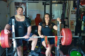 John MacDonald, left, and his partner, Jillian Sproul, take a break from training at their Charlottetown home. MacDonald and Sproul are both representing Canada at the International Powerlifting Federation (IPF) bench press world championships in Austin, Texas, this week. Jason Simmonds • The Guardian