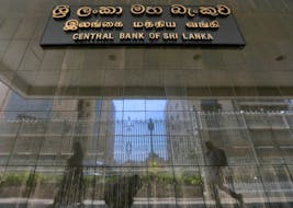 People walk past the main entrance of the Sri Lanka's Central Bank in Colombo, Sri Lanka March 24, 2017.