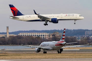 An American Airlines aircraft taxis as a Delta Air Lines aircraft lands at Reagan National Airport in Arlington, Virginia, U.S., January 24, 2022.  