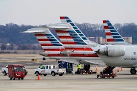 Ground crews work around American Airlines aircraft at Reagan National Airport in Arlington, Virginia, U.S., January 24, 2022.  